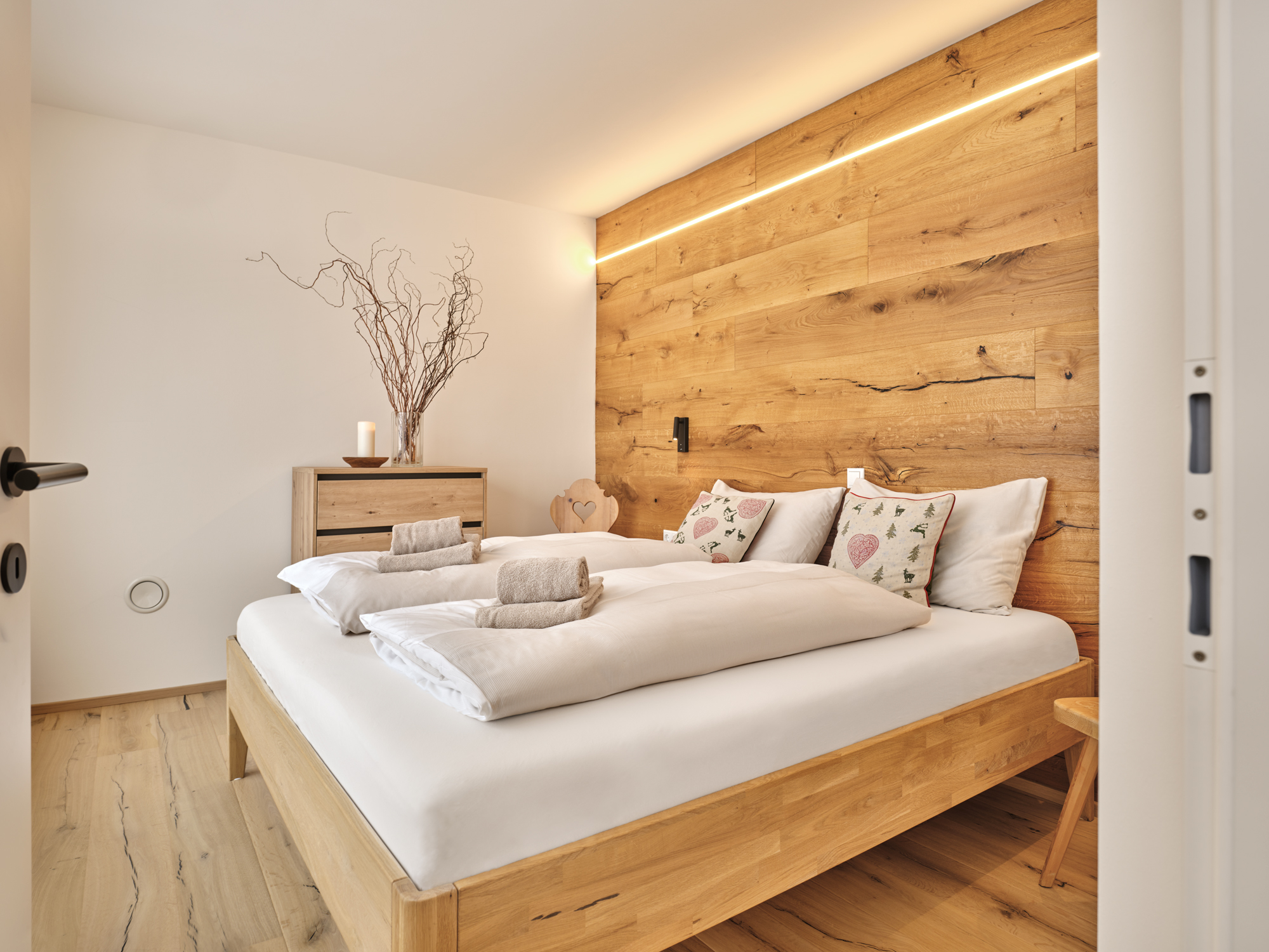 White linen against a reclaimed larch wall, snow-light through glass