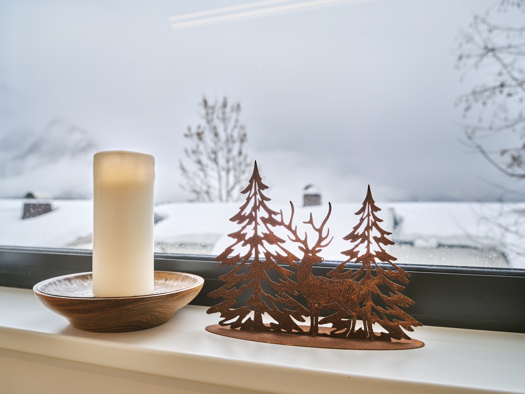 A candle at the window, snow to the ridge